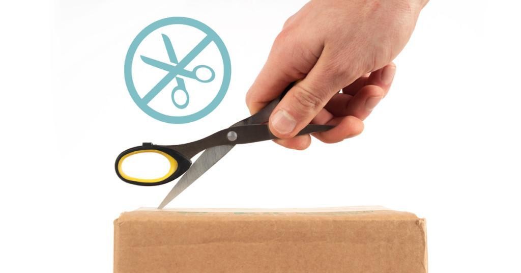 Cutting into the top of a box with scissors, with a "no scissors" graphic in the top left corner.